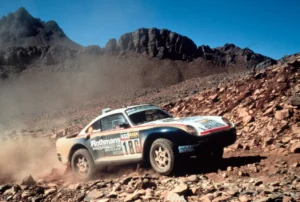 Box art of the Gunze Sangyo 1:24 scale Porsche 959 Rally Paris-Dakar High Rider plastic model kit featuring the #185 Rothmans livery