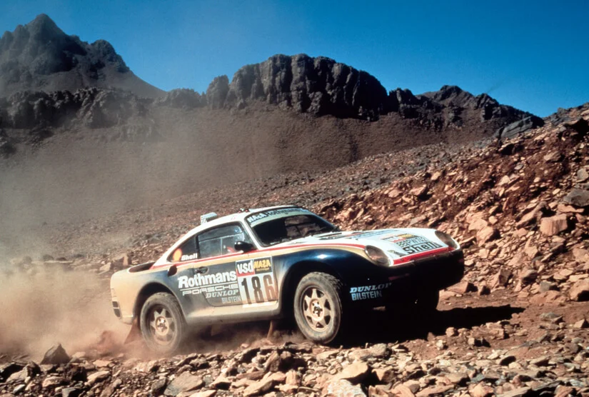 Box art of the Gunze Sangyo 1:24 scale Porsche 959 Rally Paris-Dakar High Rider plastic model kit featuring the #185 Rothmans livery